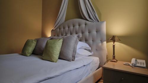 a bedroom with a white bed with a phone on a table at Vozdvyzhensky Boutique Hotel in Kyiv