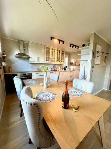 a kitchen with a wooden table with a bottle of wine at Top location - Amazing views in Tromsø