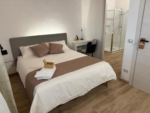a bedroom with a large white bed and a bathroom at B&B Carrubba - La Casa dei Nonni in Riesi
