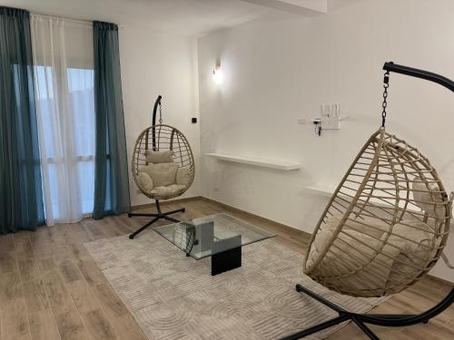 a room with two swing chairs and a glass table at B&B Carrubba - La Casa dei Nonni in Riesi