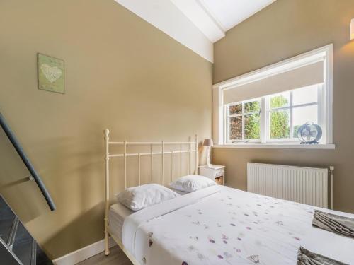 a bedroom with a bed and a window at Holiday Home Egmond near Dune Beaches in Egmond-Binnen
