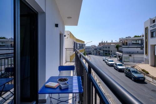 a blue table on a balcony with a view of a street at Theon Urban Suites by Nomads in Paphos City