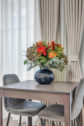 a vase of flowers on a table with two chairs at Cleveland Residences Bloomsbury in London