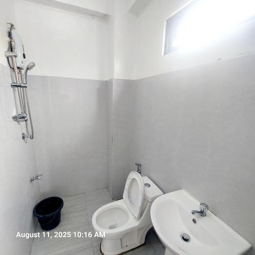 a white bathroom with a toilet and a sink at Charming 2BR Apartment with Balcony and Mountain View - Logan's Transient Apartment 2 in Baguio