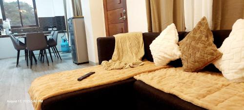 a couch with pillows and a blanket on it at Charming 2BR Apartment with Balcony and Mountain View - Logan's Transient Apartment 2 in Baguio