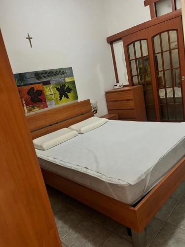 a bedroom with a bed with a wooden frame at La Casetta Bianca Vicino Mare in Vibo Valentia Marina