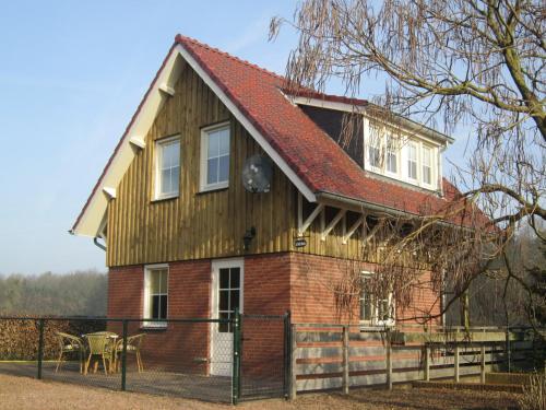 a small house with a red roof at Holiday Home in Well near Maasduinen Park in Knikkerdorp