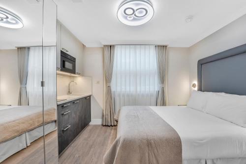 a bedroom with a large bed and a mirror at Cleveland Residences Bloomsbury in London