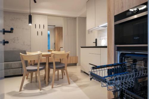 a kitchen and dining room with a table and chairs at TATRYSTAY Lebenski Premium Apartments in Vysoké Tatry