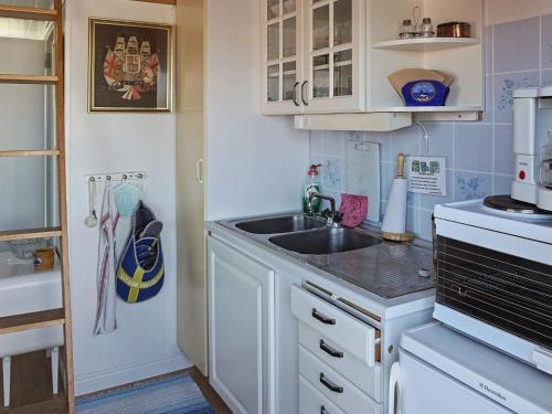 a small kitchen with a sink and a microwave at 3 person holiday home in Gullholmen in Gullholmen