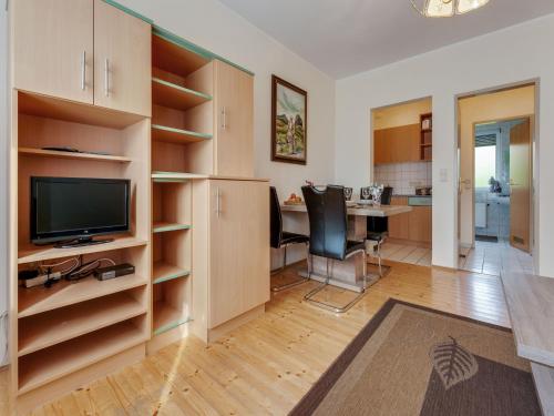 a living room with a television and a desk with chairs at Bungalow in Glödnitz near Ski Slopes in Glödnitz