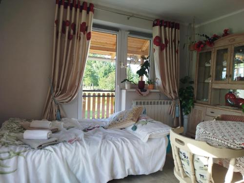 a bedroom with a white bed and a window at Retro apartament Lukas in Ostrowsko