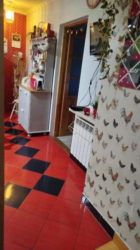 a kitchen with a refrigerator and a red tile floor at Retro apartament Lukas in Ostrowsko