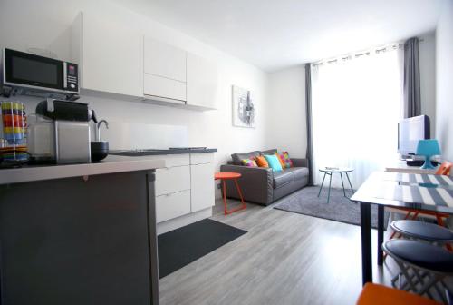 une cuisine et un salon avec un canapé dans l'établissement IDEAL Appartement Vieux Port Marseille, à Marseille