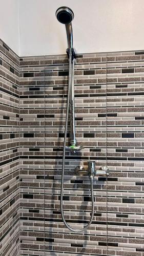 a shower in a bathroom with a brick wall at LAHANGAN SWEET cottages in Culik