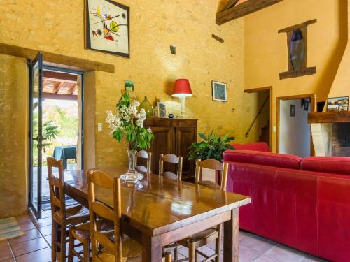 ein Wohnzimmer mit einem Holztisch und einer roten Couch in der Unterkunft Poolside Haven in Salles in Larzac