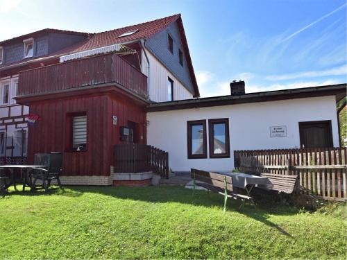 a red and white house with a bench in the yard at Familienspaß & Waldwege in Ilsenburg in Ilsenburg