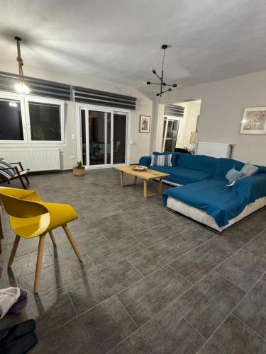 ein Wohnzimmer mit einem blauen Sofa und einem Tisch in der Unterkunft Pines Flat in Fourka