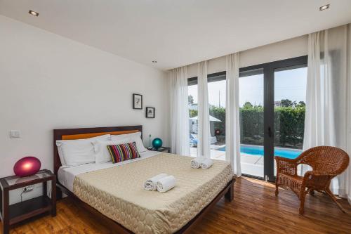 a bedroom with a bed and a view of a pool at Sesimbra Villa with Private Pool and Garden - Total Privacy in Sesimbra