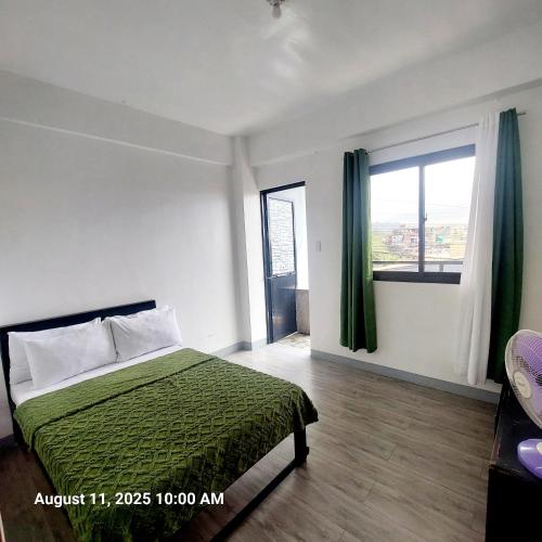 a bedroom with a bed and a large window at Charming 2BR Apartment with Balcony and Mountain View - Logan's Transient Apartment 2 in Baguio