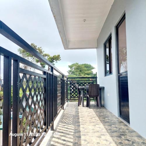 a balcony of a house with a table and chairs at Charming 2BR Apartment with Balcony and Mountain View - Logan's Transient Apartment 2 in Baguio