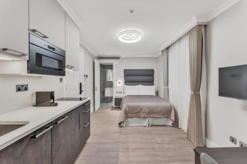 a bedroom with a bed and a tv in a room at Cleveland Residences Bloomsbury in London