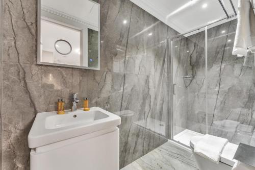 a bathroom with a white sink and a shower at Cleveland Residences Bloomsbury in London