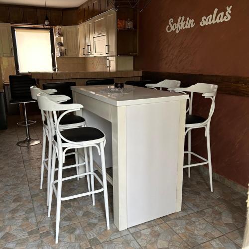 a bar with white stools in a kitchen at Sofkin salas in Prijedor