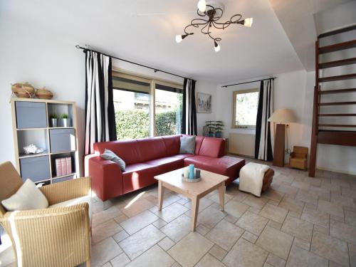 a living room with a red couch and a table at Villa in Bruinisse near Grevelingenmeer in Bruinisse