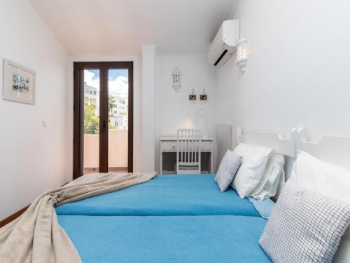 a bedroom with a large bed with blue sheets at Akivillas Quarteira Lighten in Quarteira