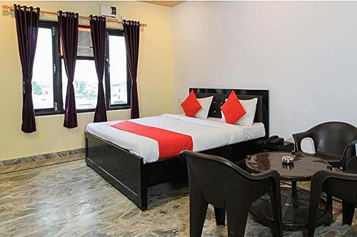 a hotel room with a bed and a table and chairs at HoTEL MEHRAZ in Haldwāni