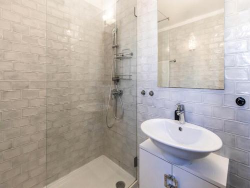 a white bathroom with a sink and a shower at Akivillas Quarteira Lighten in Quarteira