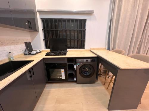 a kitchen with a washing machine under a counter at Villa de l'atlantique in Abomey-Calavi