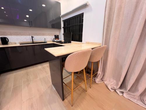 a kitchen with a counter and two chairs at a table at Villa de l'atlantique in Abomey-Calavi