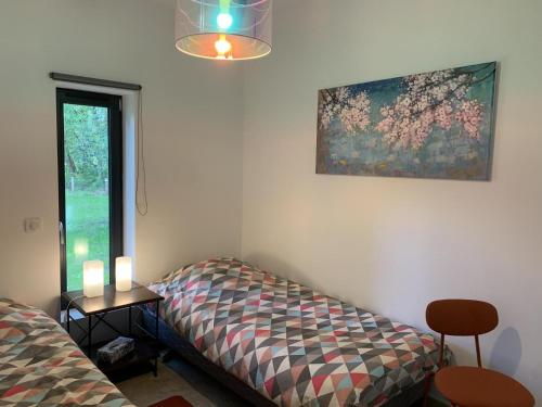 a room with a bed and a painting on the wall at Gite du cache in Labrit