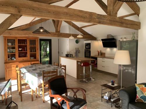 a kitchen and living room with a table and chairs at Gite du cache in Labrit