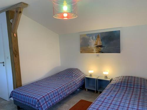 a bedroom with two beds and a painting of a sailboat at Gite du cache in Labrit