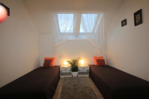 a small room with two beds and a window at Penzion Lamberk in Nový Jičín