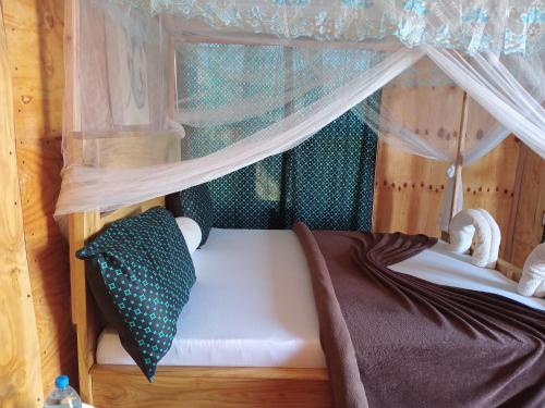 a small bed in a play house with a canopy at Patience Airport cottages in Boma la Ngombe