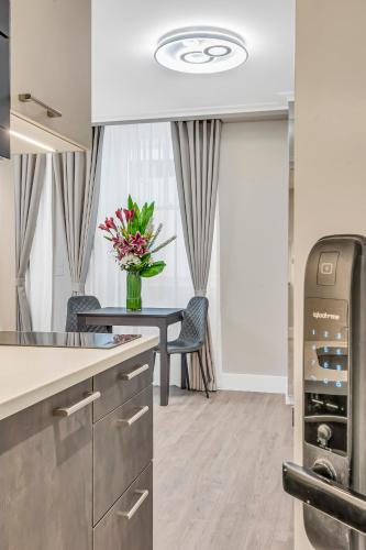 a kitchen with a table with a vase of flowers at Cleveland Residences Bloomsbury in London