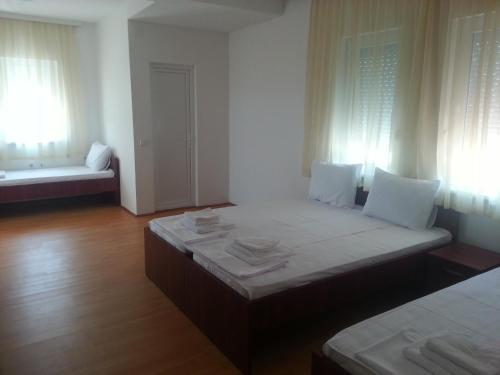 um quarto com uma cama, um sofá e janelas em Apartmani Marija em Star Dojran