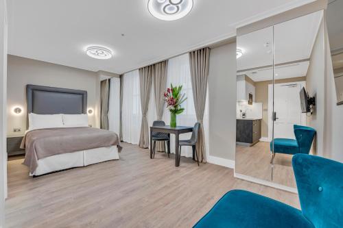a hotel room with a bed and a table and chairs at Cleveland Residences Bloomsbury in London