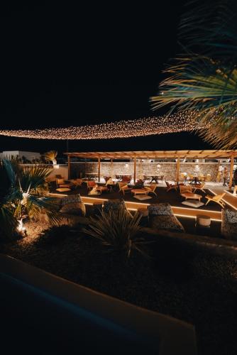 a group of tables and chairs on the beach at night at Irene's Residence in Mikonos