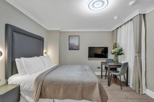 a hotel room with a bed and a desk at Cleveland Residences Bloomsbury in London