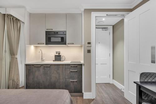 a kitchen with a sink and a microwave at Cleveland Residences Bloomsbury in London