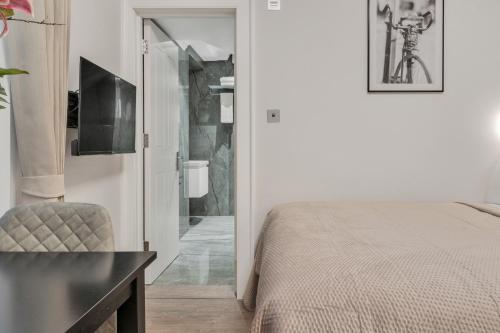 a bedroom with a bed and a chair and a television at Cleveland Residences Bloomsbury in London