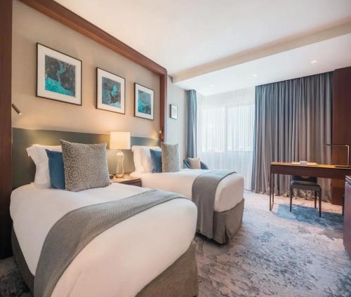 a hotel room with two beds and a piano at Hotel TuLiP Inn Near Delhi Airport in New Delhi