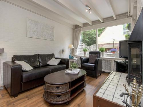 a living room with a couch and a table at Holiday Home in Noordwijkerhout by Forest & Lake in Noordwijkerhout