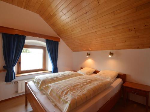 ビュートゲンバッハにあるHoliday home in Butgenbach near the Lakeの木製の天井の客室のベッド1台分です。