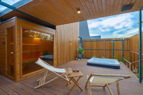 a deck with a hammock and a tub on it at Natur Harmony Tiszafüred in Tiszafüred